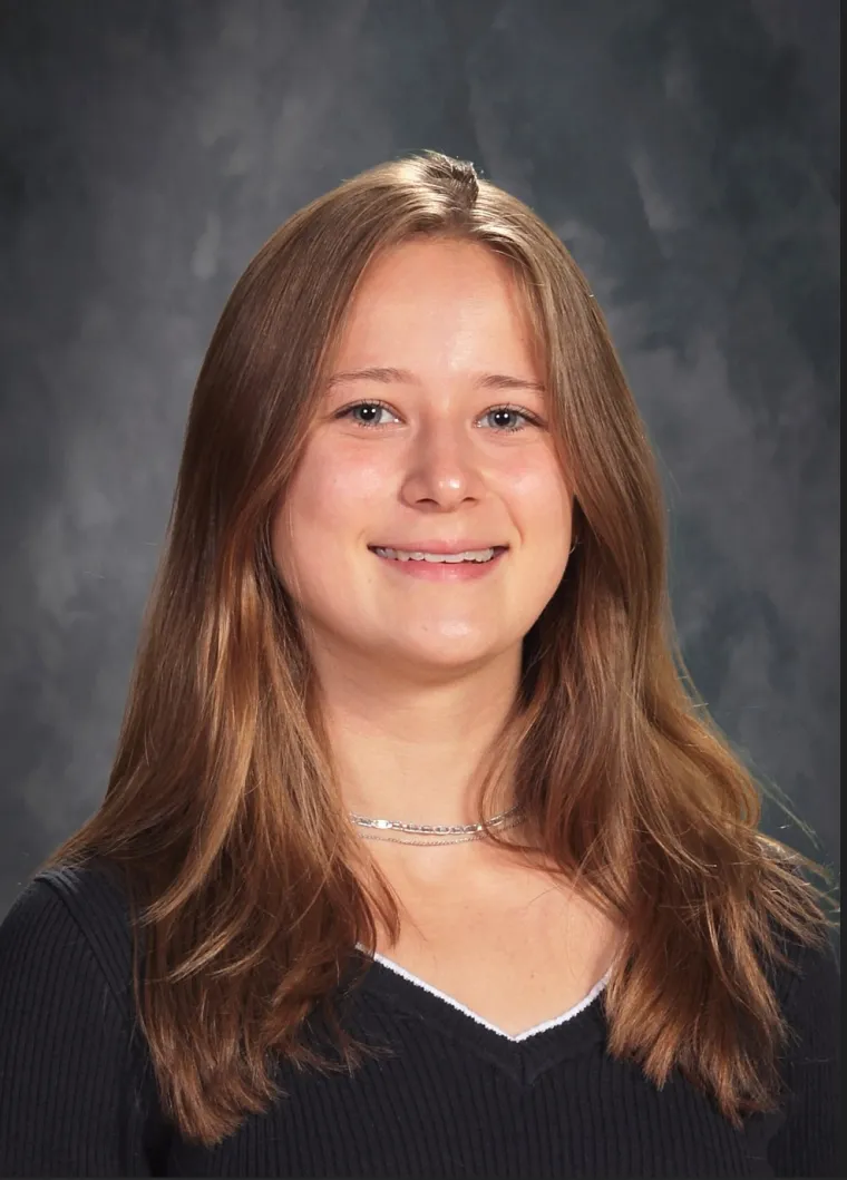 headshot of a person with a grey backdrop