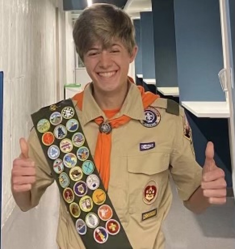 person giving a thumbs up sign wearing a scouting uniform.
