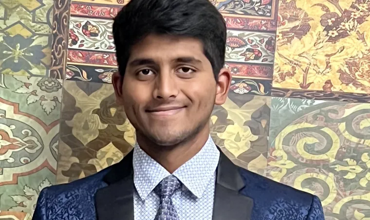 headshot of a person standing in front of a colorful patterned background