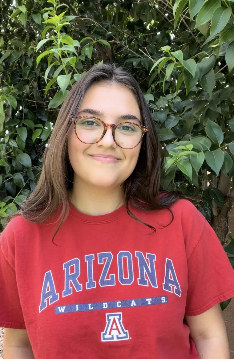 headshot of a person with trees in the background