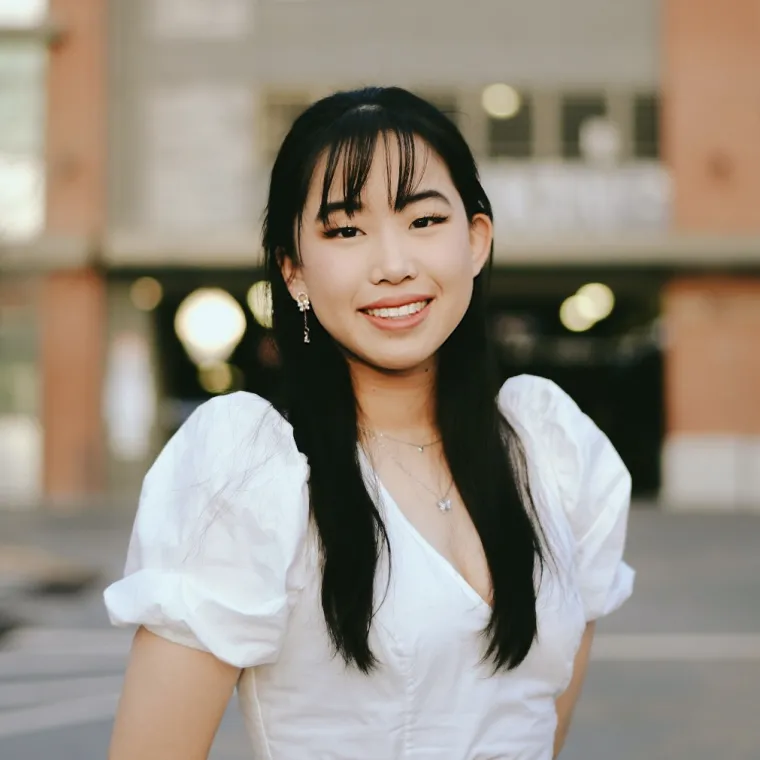 headshot of a person standing in front of a building